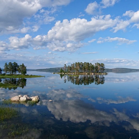 En sjö med öar och berg i bakgrunden.